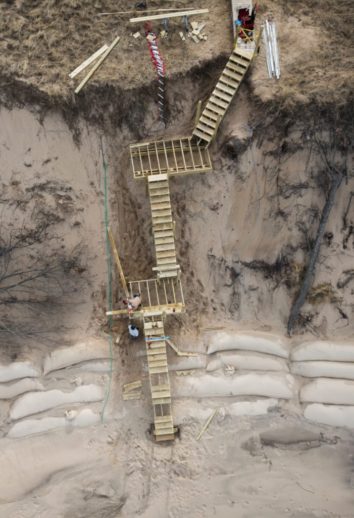 overhead view of a wooden staircase going down a sand dune