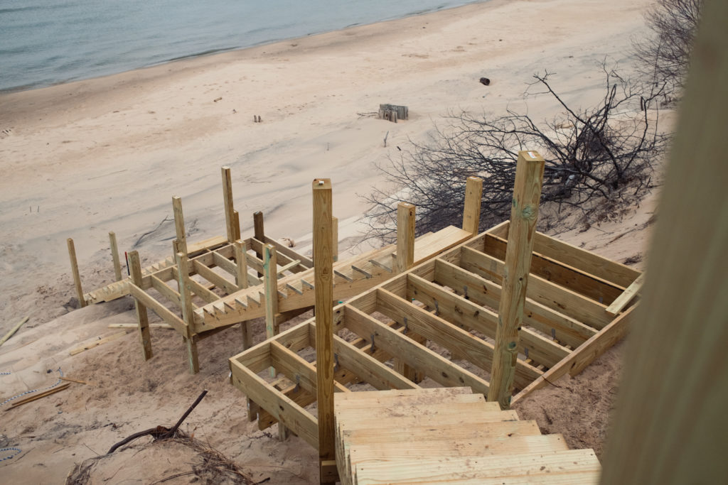 Building wooden staircase leading down dune