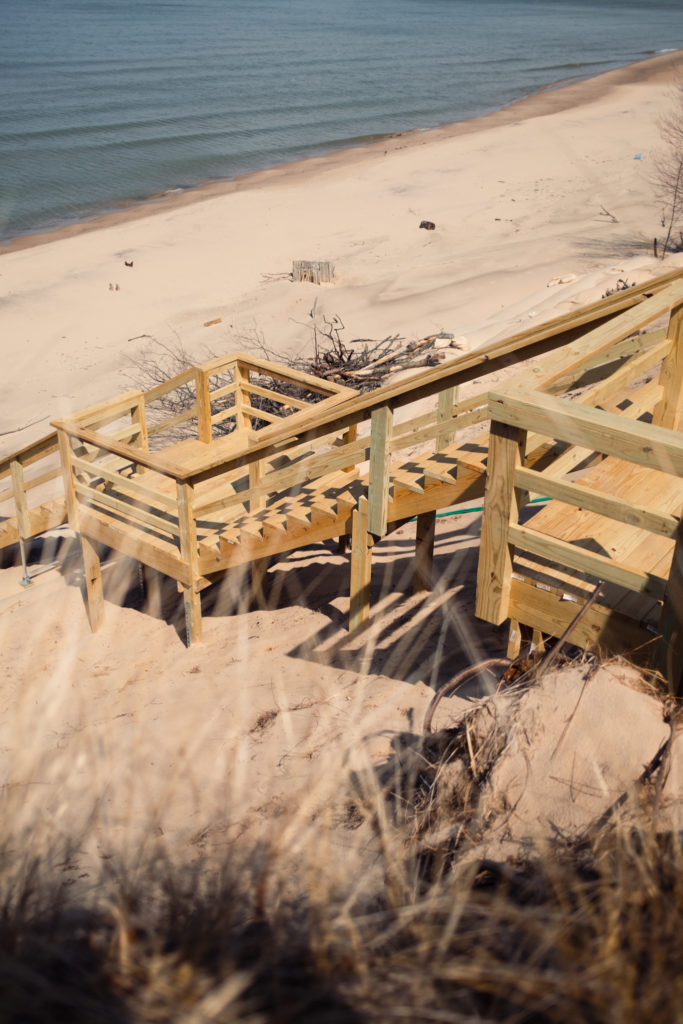 New staircase leading to beach with surrounding winter debris