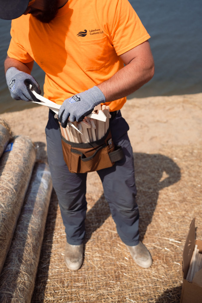 Worker supplying pouch with bio-friendly wooden netting pegs