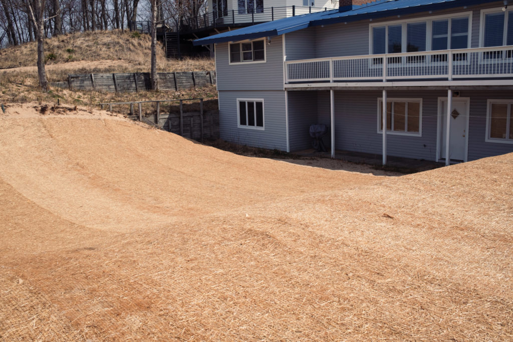 Completed yard with straw mat covering behind house