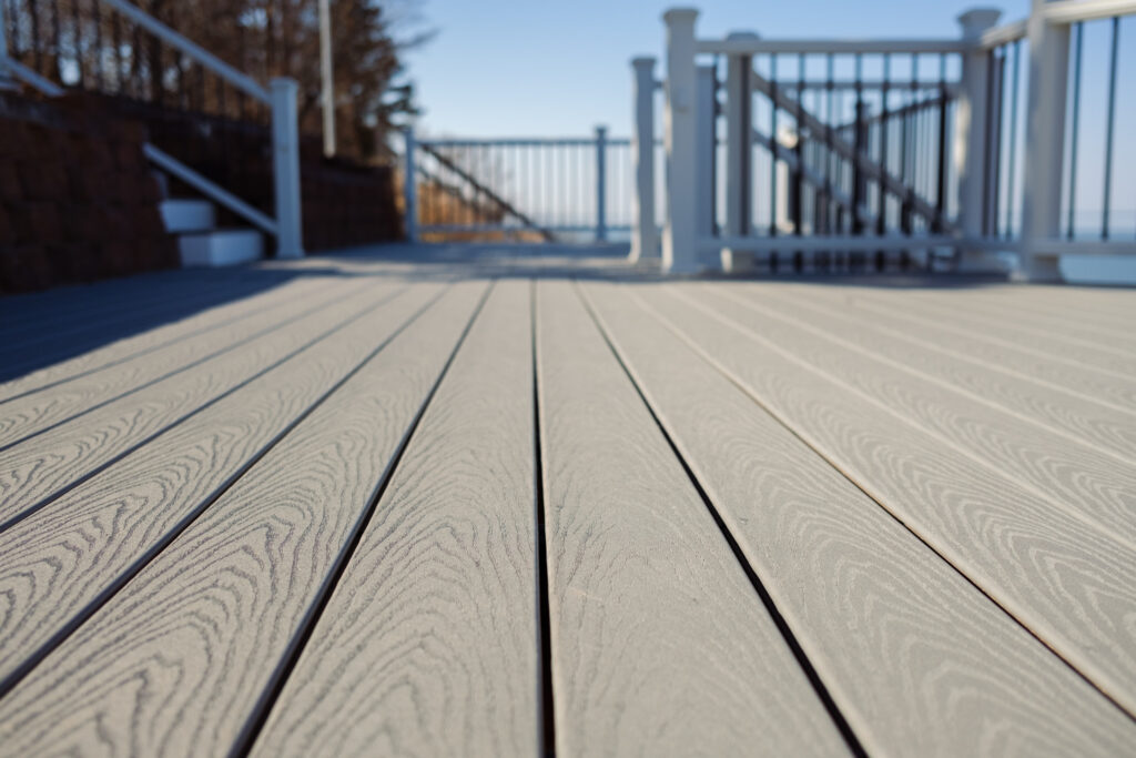 Close up of a gray composite deck just off the shore of Lake Michigan
