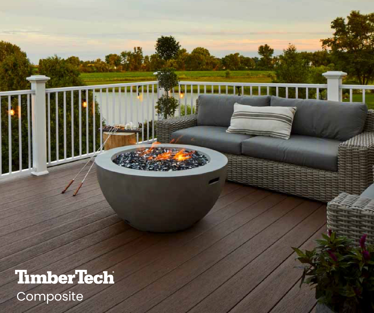 A finished, dark brown composite TimberTech deck complete with a fire pit and gray outdoor furniture.