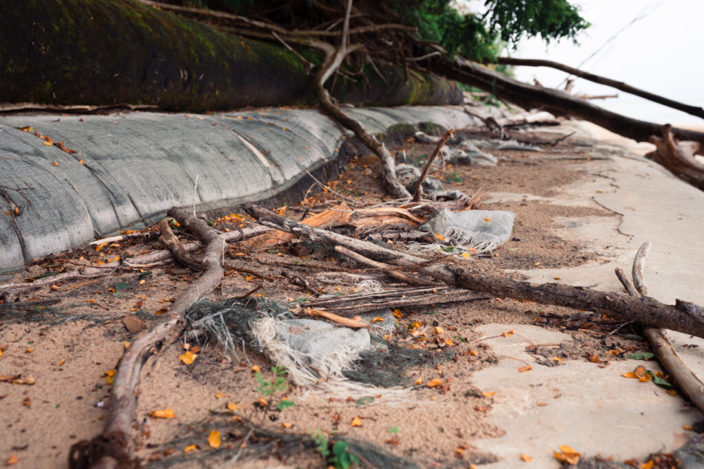 Debris and dirt by geotextile sandbags on the beach