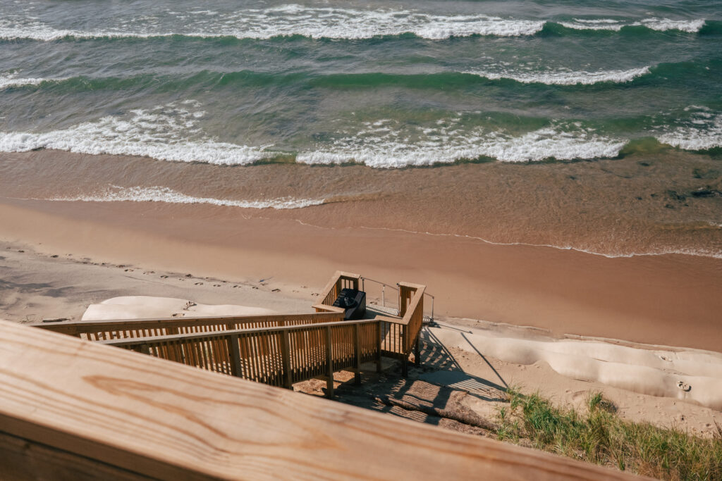 View of the lakeshore from a deck, with staircase and geotextile sandbags in view