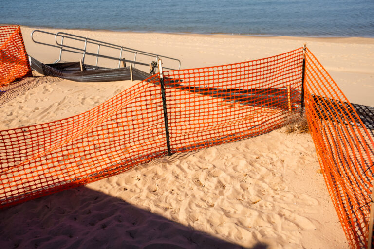 Orange lightweight snow fencing installed on a Lake Michigan beach