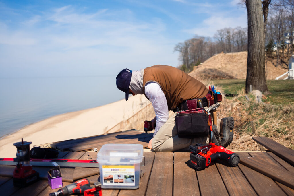 A Lakeshore Customs contractor drills decking in place along Lake Michigan.