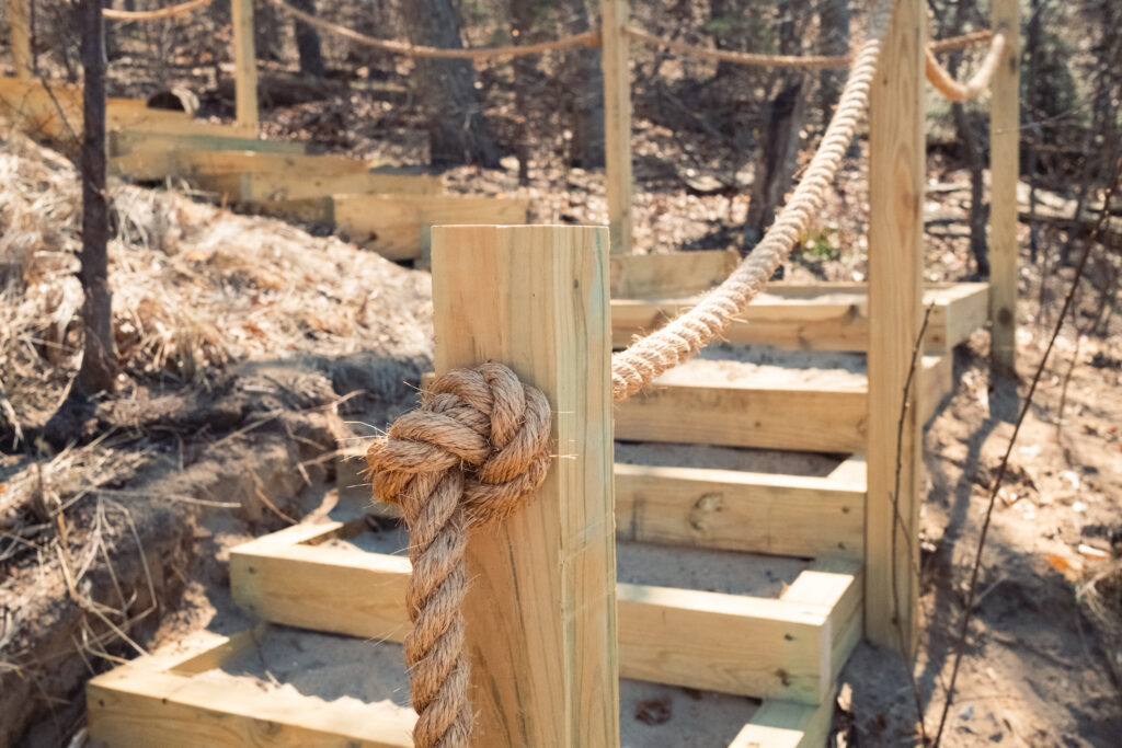 Retaining earth steps with a custom rope railing.